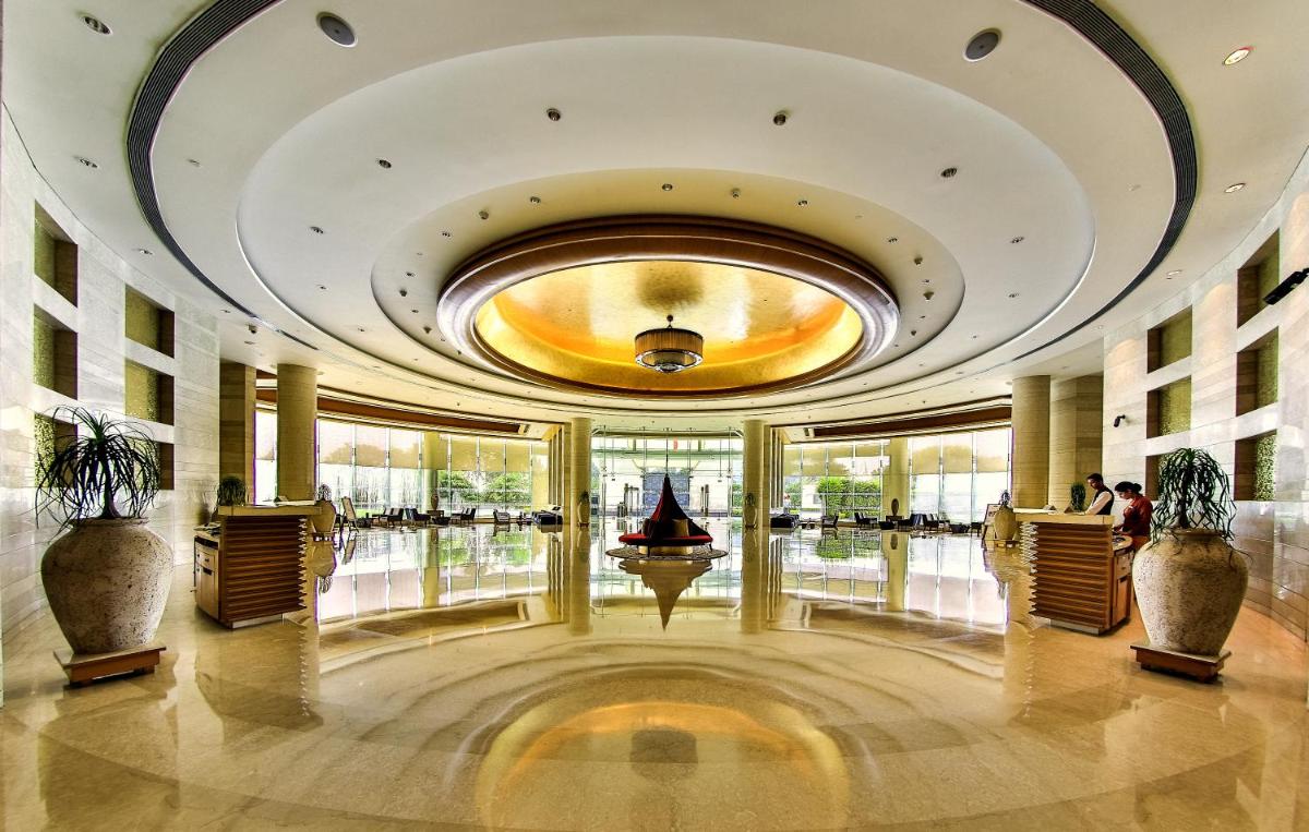 a lobby with a large building with a boat in it at The Lalit Chandigarh in Chandīgarh