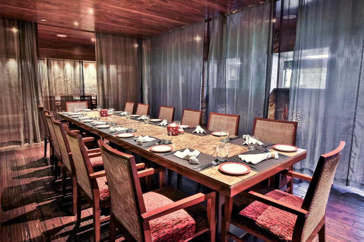 a long wooden table in a room with chairs and a tableablish at The Lalit Chandigarh in Chandīgarh