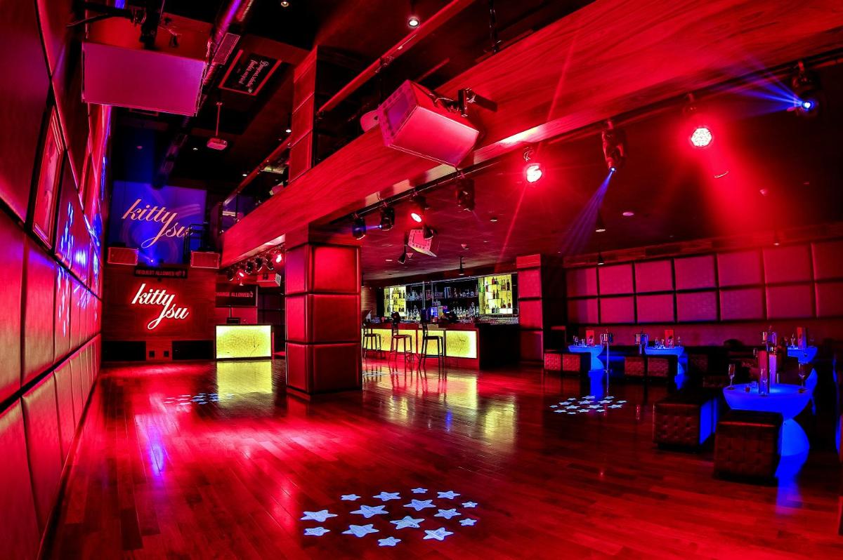 a room with red lights and a bar with tables at The Lalit Chandigarh in Chandīgarh