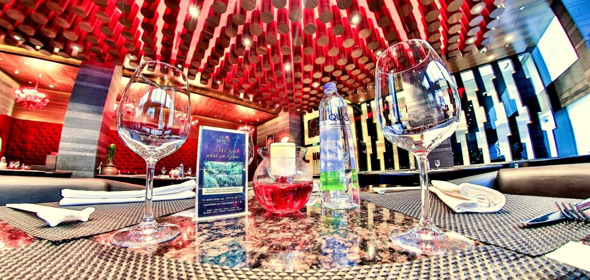 a table with four wine glasses on top of it at The Lalit Chandigarh in Chandīgarh