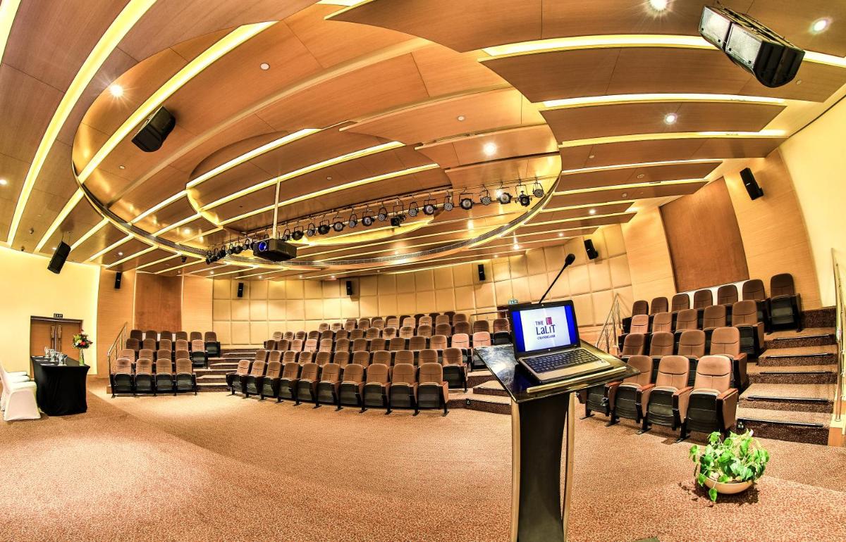 a large auditorium with chairs and a laptop on a podium at The Lalit Chandigarh in Chandīgarh