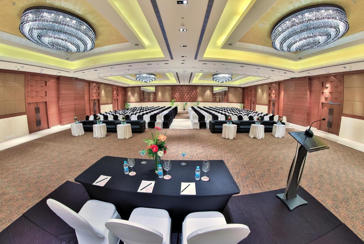 a banquet hall with a black table and white chairs at The Lalit Chandigarh in Chandīgarh +94 photos