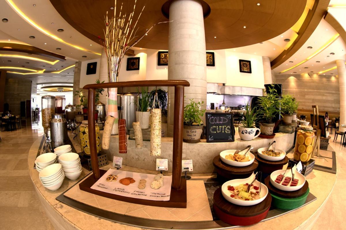 a restaurant with food on display in a lobby at The Lalit Chandigarh in Chandīgarh