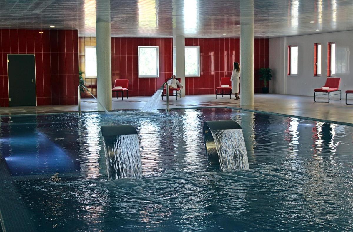 uma grande piscina com água num edifício em Palace Hotel Astúrias & Spa em Carvalhal