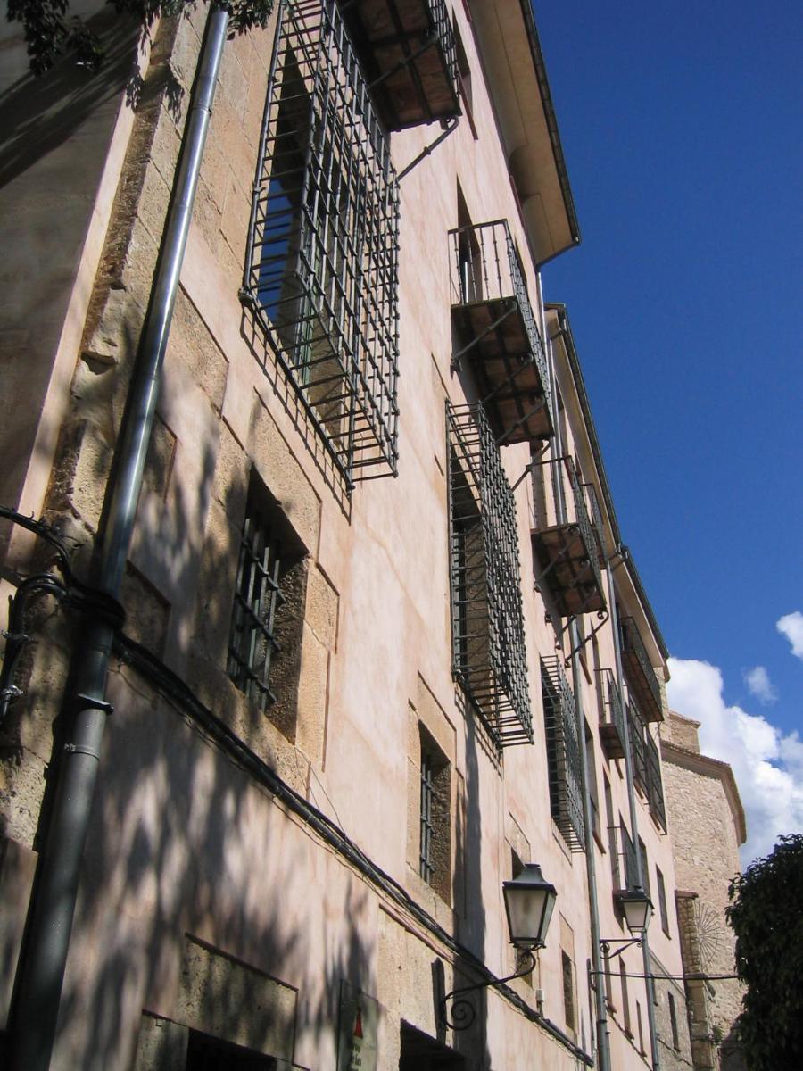 Un edificio alto con ventanas y balcones. en Hotel Leonor de Aquitania, en Cuenca