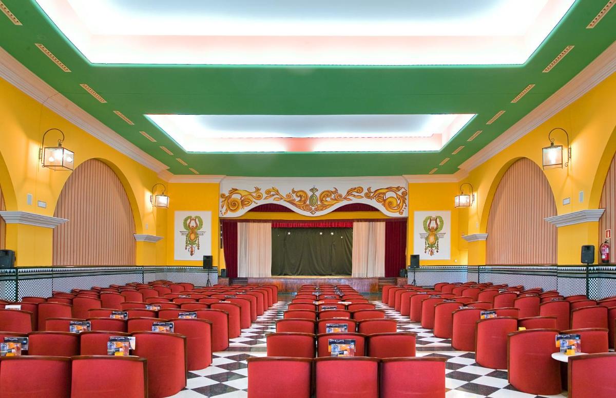 Un auditorio vacío con sillas rojas y un escenario. en Playacartaya, en El Portil 52 fotos más