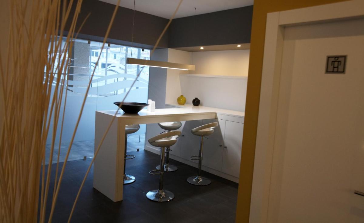 Una cocina con encimera y taburetes en una habitación. en Hotel Bienestar Moaña, en Moaña