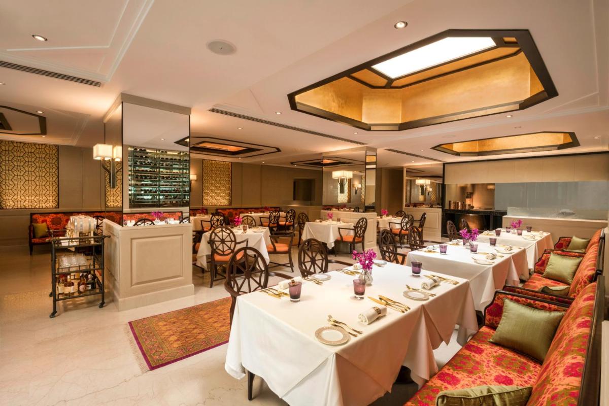 a dining room with white tables and chairs at The Oberoi New Delhi in New Delhi a dining room with white tables and chairs at The Oberoi New Delhi in New Delhi