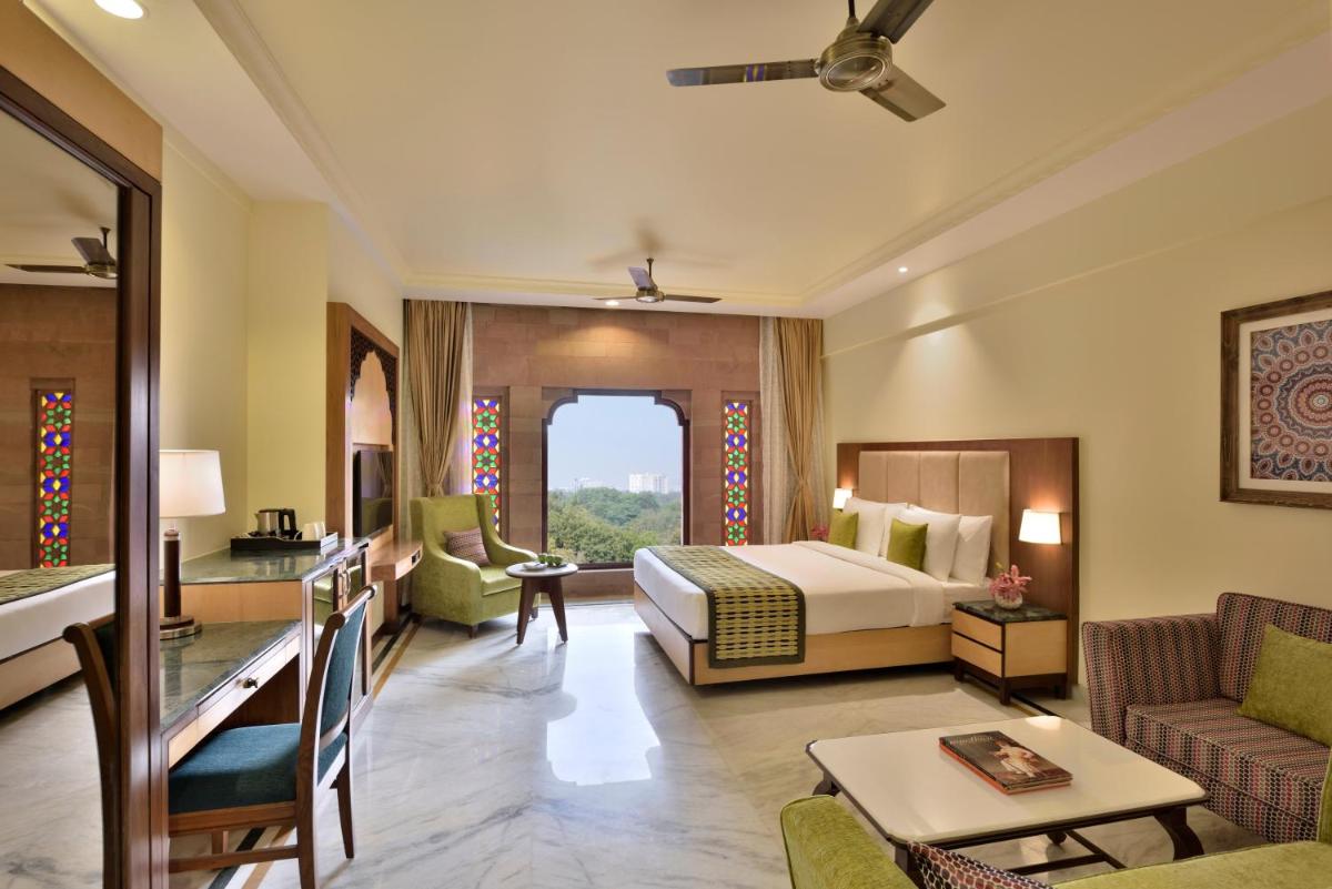 a hotel room with a bed and a living room at Radisson Jodhpur in Jodhpur