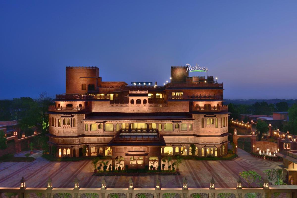 a large building with lights on it at night at Radisson Jodhpur in Jodhpur