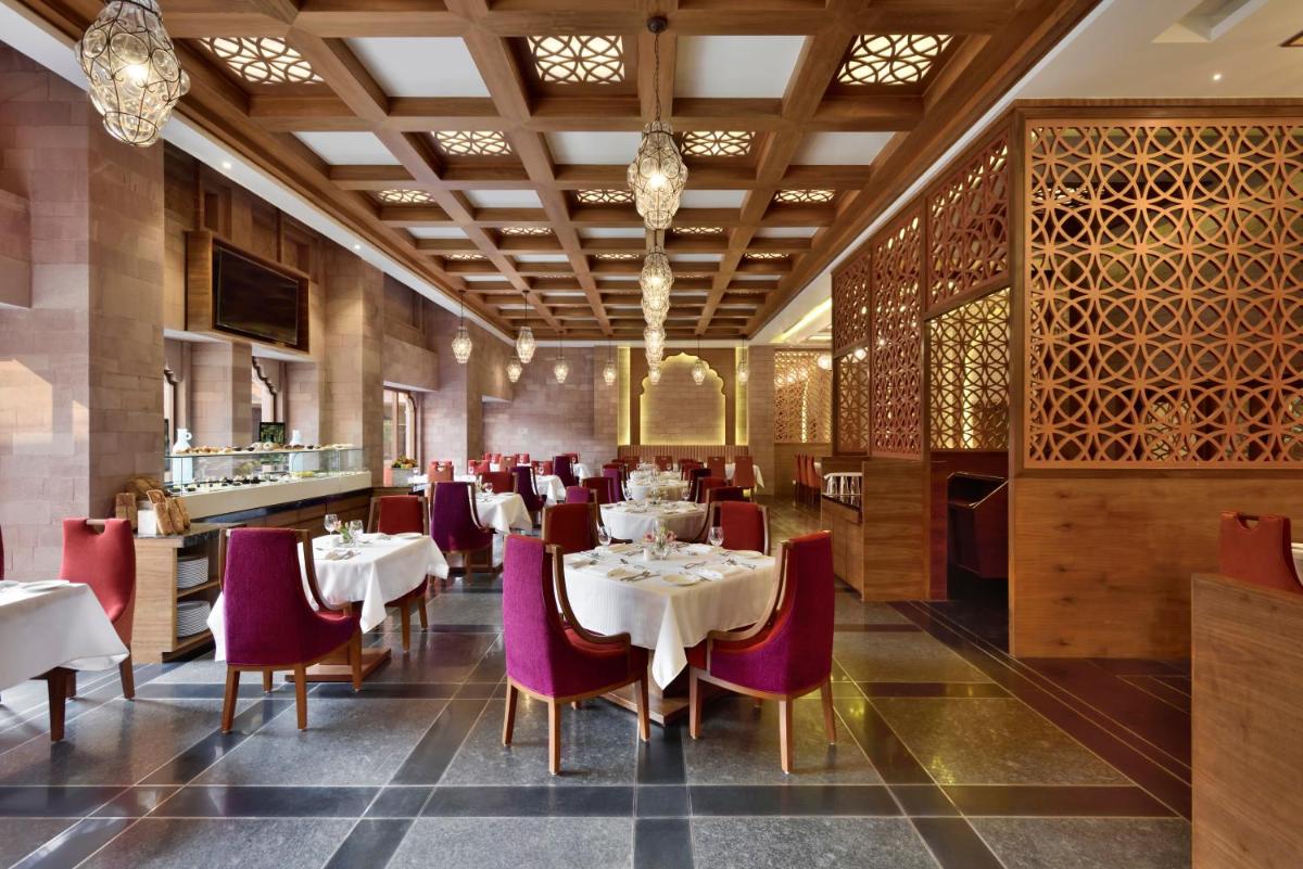 a dining room with white tables and purple chairs at Radisson Jodhpur in Jodhpur