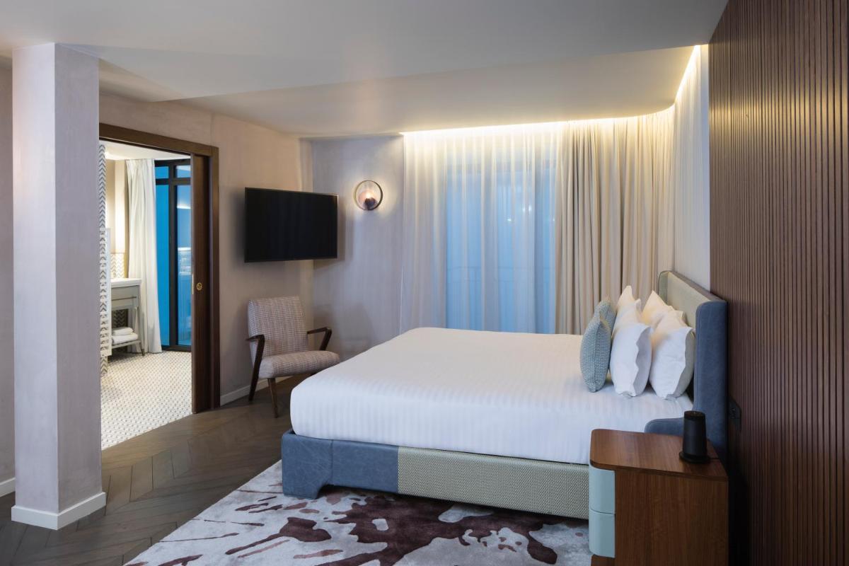une chambre d'hôtel avec un lit et une télévision dans l'établissement Maison Bréguet, à Paris