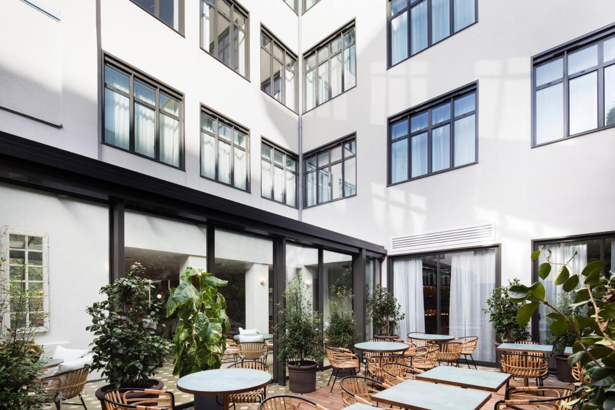une cour intérieure d'un bâtiment avec des tables et des chaises dans l'établissement Maison Bréguet, à Paris
