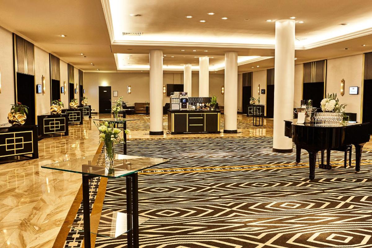 eine Lobby mit einem Flügel und einer großen Orgel in der Unterkunft Steigenberger Hotel Bad Homburg in Bad Homburg vor der Höhe eine Lobby mit einem Flügel und einer großen Orgel in der Unterkunft Steigenberger Hotel Bad Homburg in Bad Homburg vor der Höhe