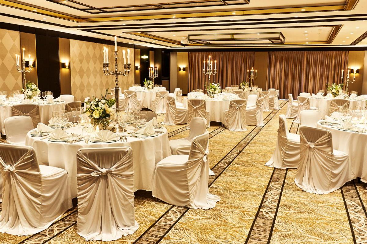 ein Raum voller Tische und Stühle mit weißer Tischwäsche in der Unterkunft Steigenberger Hotel Bad Homburg in Bad Homburg vor der Höhe ein Raum voller Tische und Stühle mit weißer Tischwäsche in der Unterkunft Steigenberger Hotel Bad Homburg in Bad Homburg vor der Höhe
