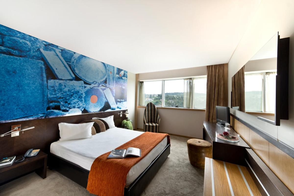 um quarto de hotel com uma cama e uma TV em Penafiel Park Hotel & Spa em Penafiel