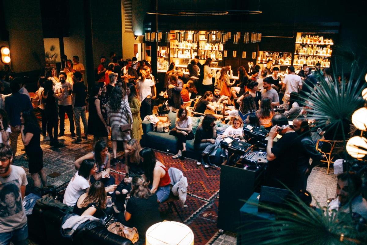 Una multitud de personas sentadas en una habitación con un bar. en Hotel Casa Bonay & Spa, en Barcelona
