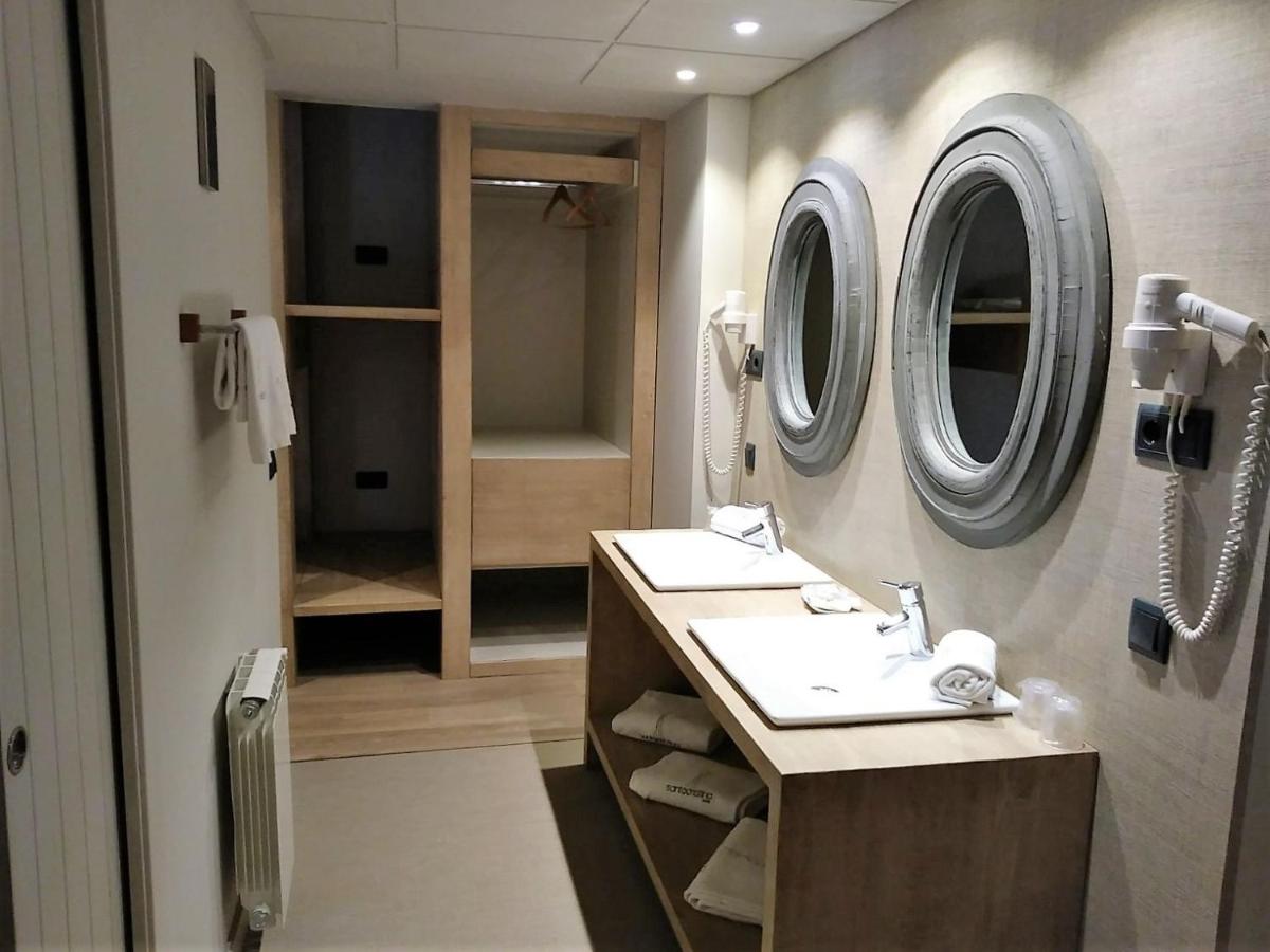 Un baño con dos lavabos y un espejo. en Hotel Santa Cristina Petit Spa, en Canfranc-Estación