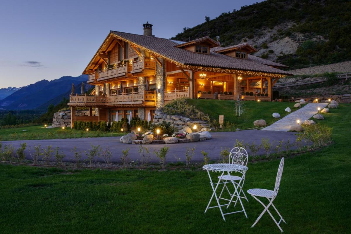 Una gran casa de madera con dos sillas y una mesa. en Hotel Viñas de Lárrede, en Lárrede
