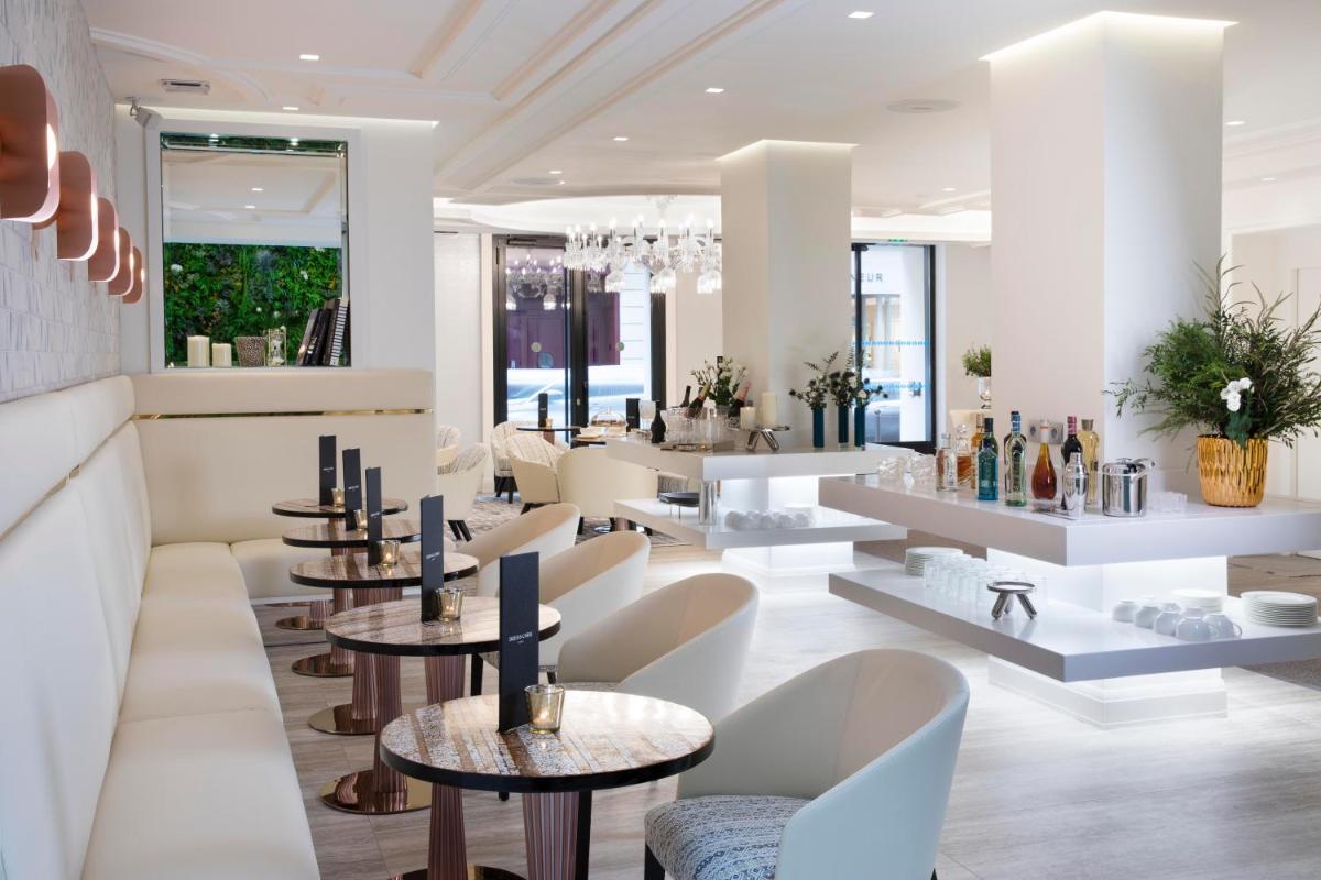 un restaurant avec des tables et des chaises dans une salle dans l'établissement Hôtel Dress Code, à Paris