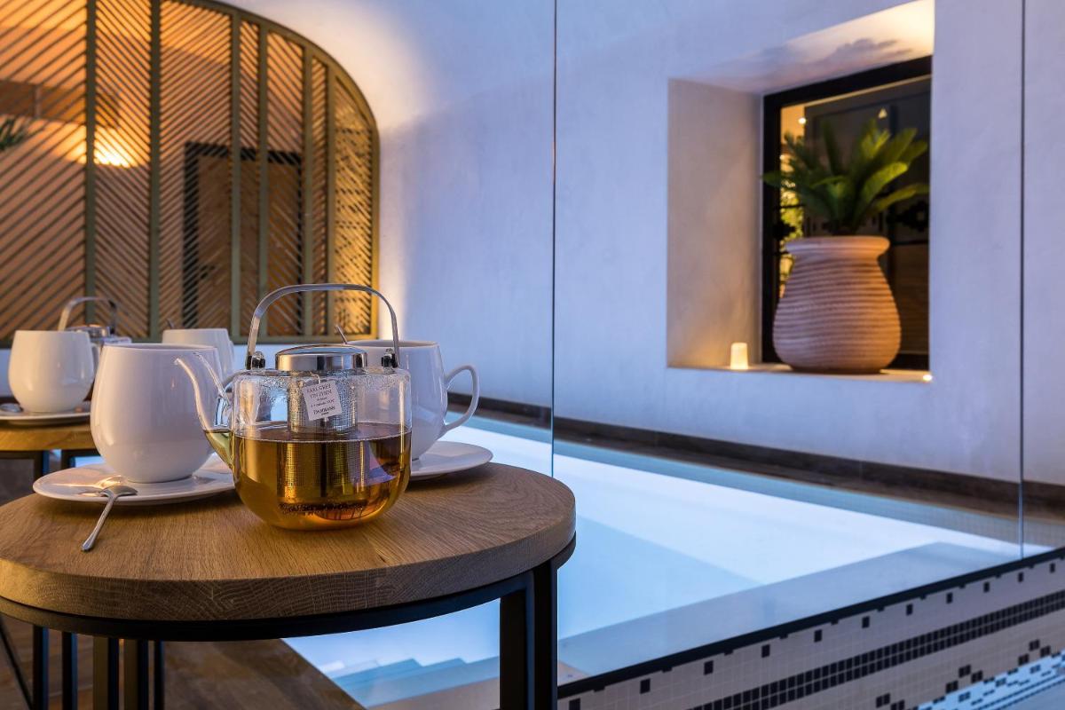 - une tasse de thé assise sur une table au bord de la piscine dans l'établissement Laz' Hotel Spa Urbain Paris, à Paris