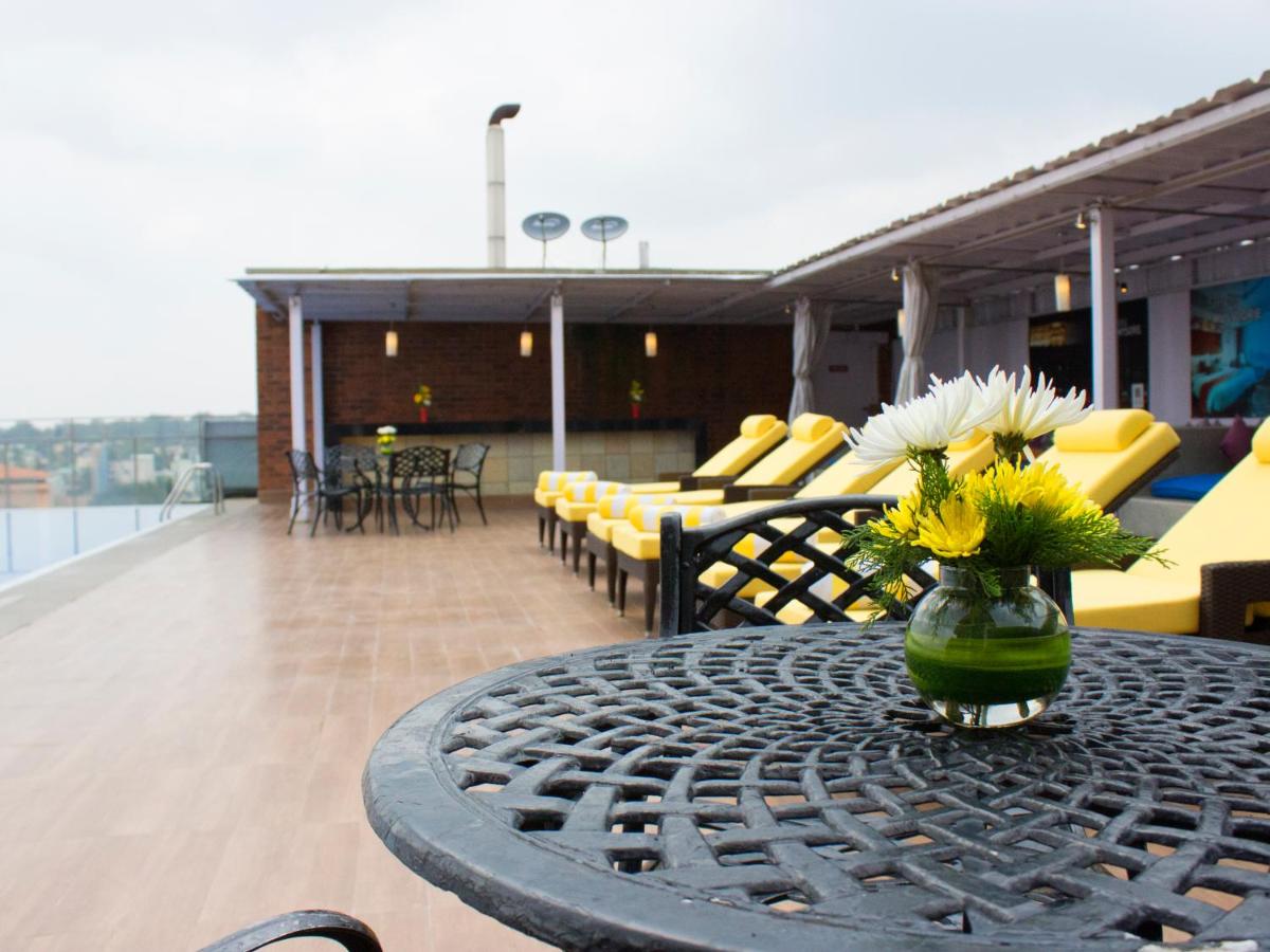 a vase of flowers sitting on a table on a balcony at Hotel Royal Orchid Bangalore in Bengaluru