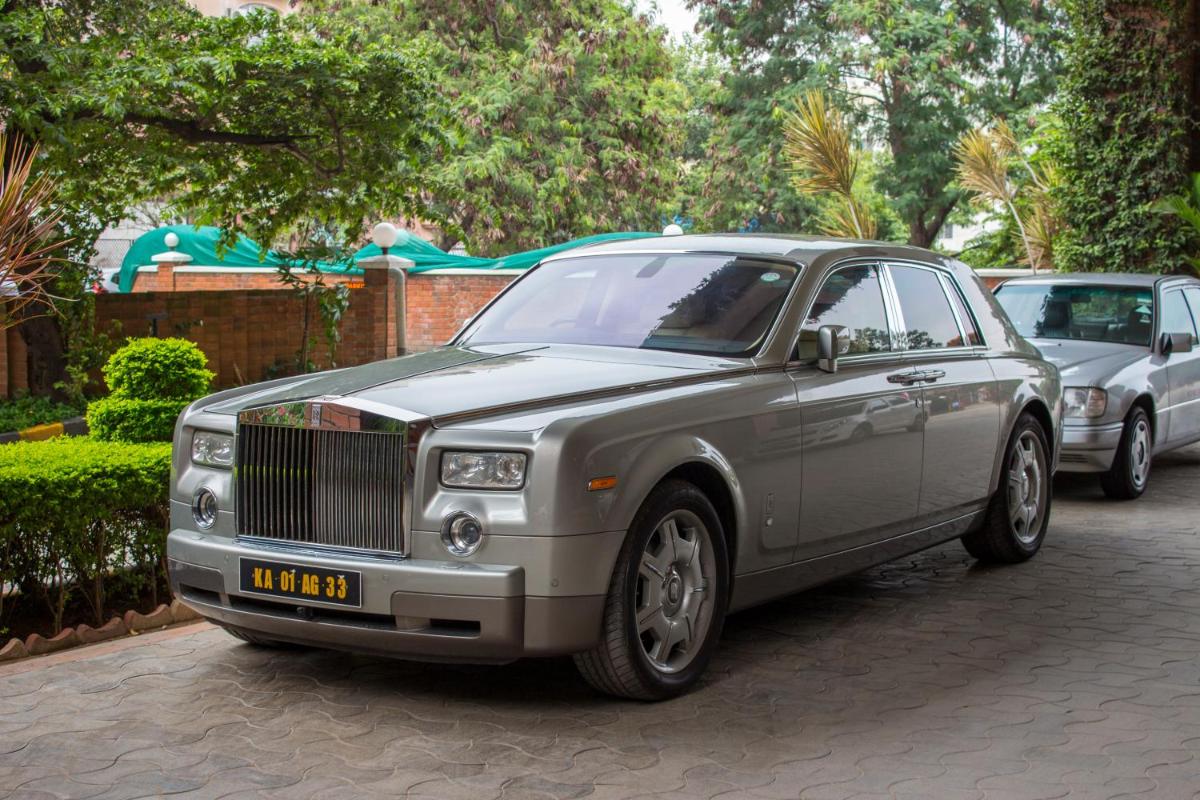 a silver car parked on a street next to other cars at Hotel Royal Orchid Bangalore in Bengaluru
