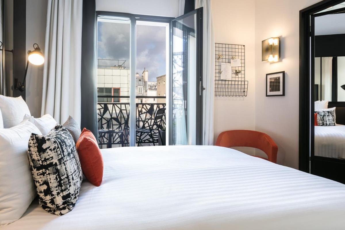 une chambre avec un grand lit blanc avec une fenêtre dans l'établissement Laz' Hotel Spa Urbain Paris, à Paris