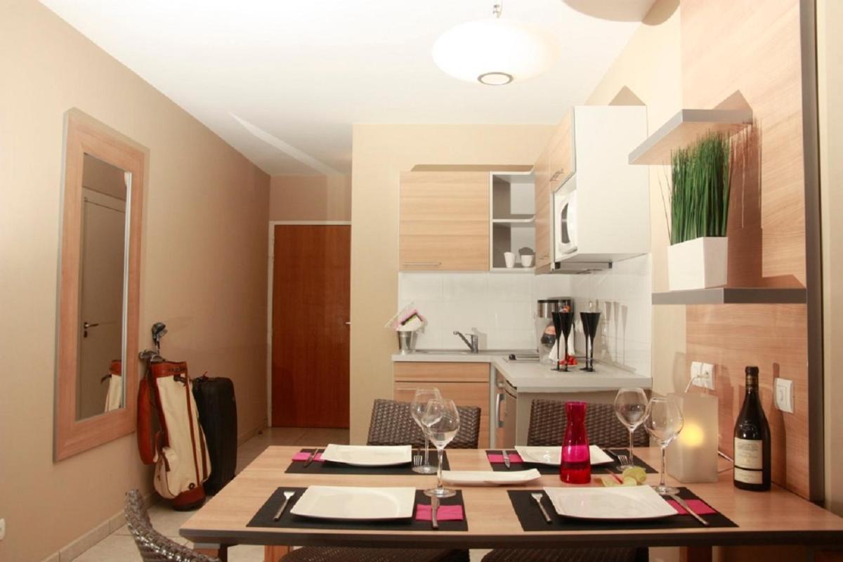 une salle à manger avec une table et une cuisine dans l'établissement Résidence Hôtelière Natureva & Spa, au Cap d'Agde