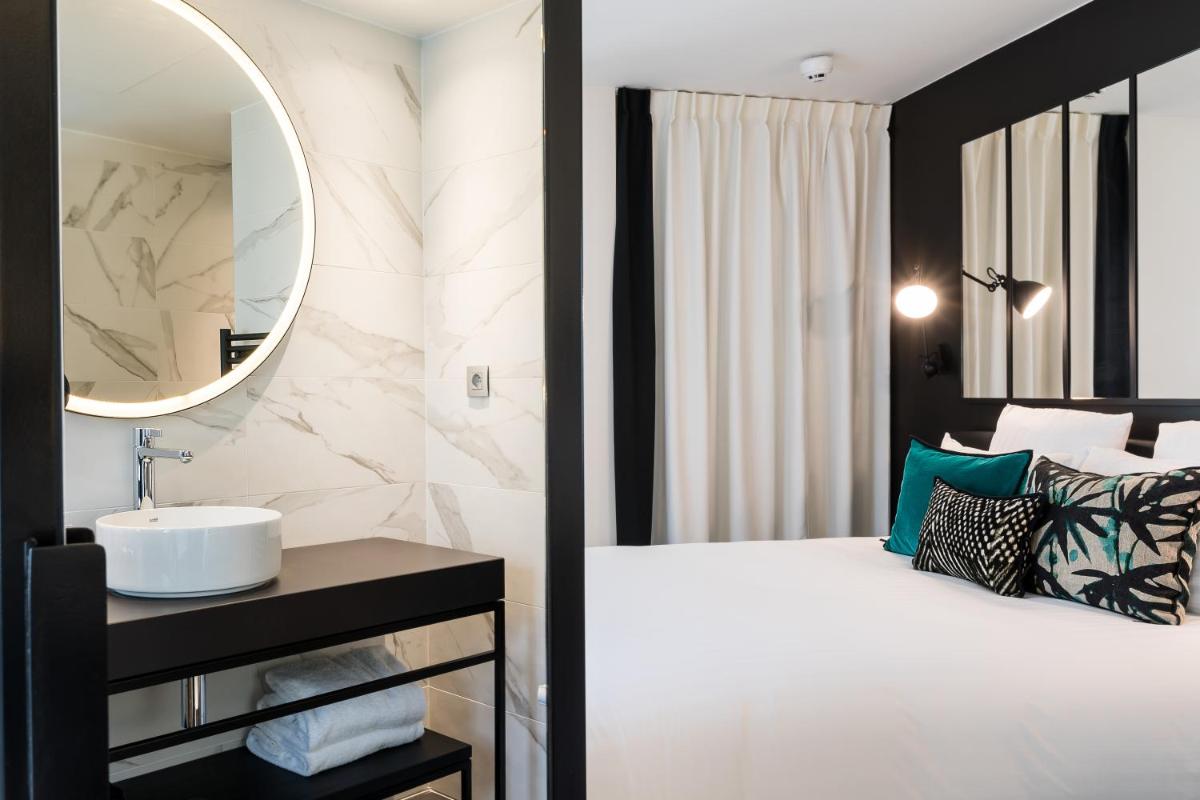 Un ou plusieurs lits dans un hébergement de l'établissement Laz' Hotel Spa Urbain Paris