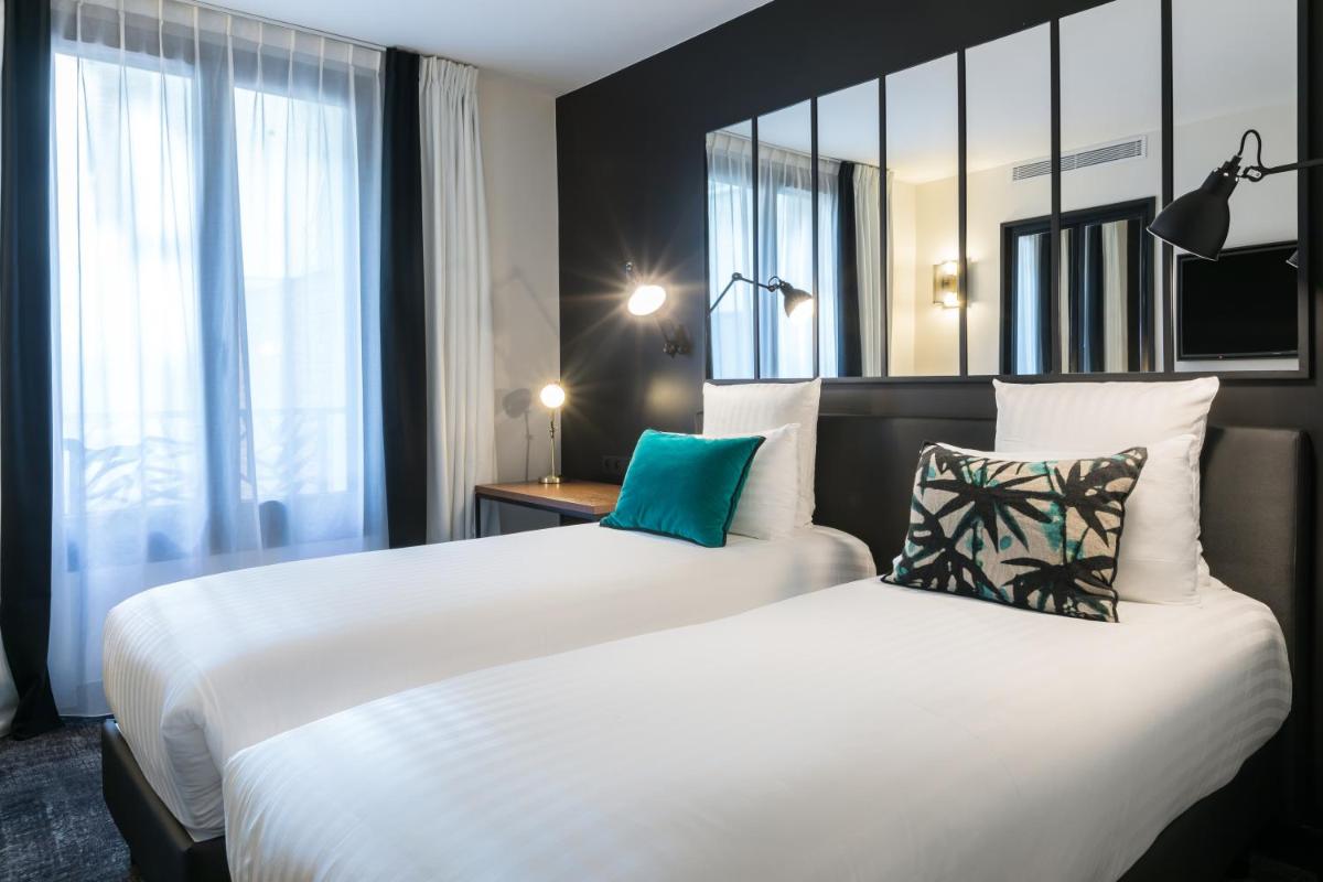 Un ou plusieurs lits dans un hébergement de l'établissement Laz' Hotel Spa Urbain Paris
