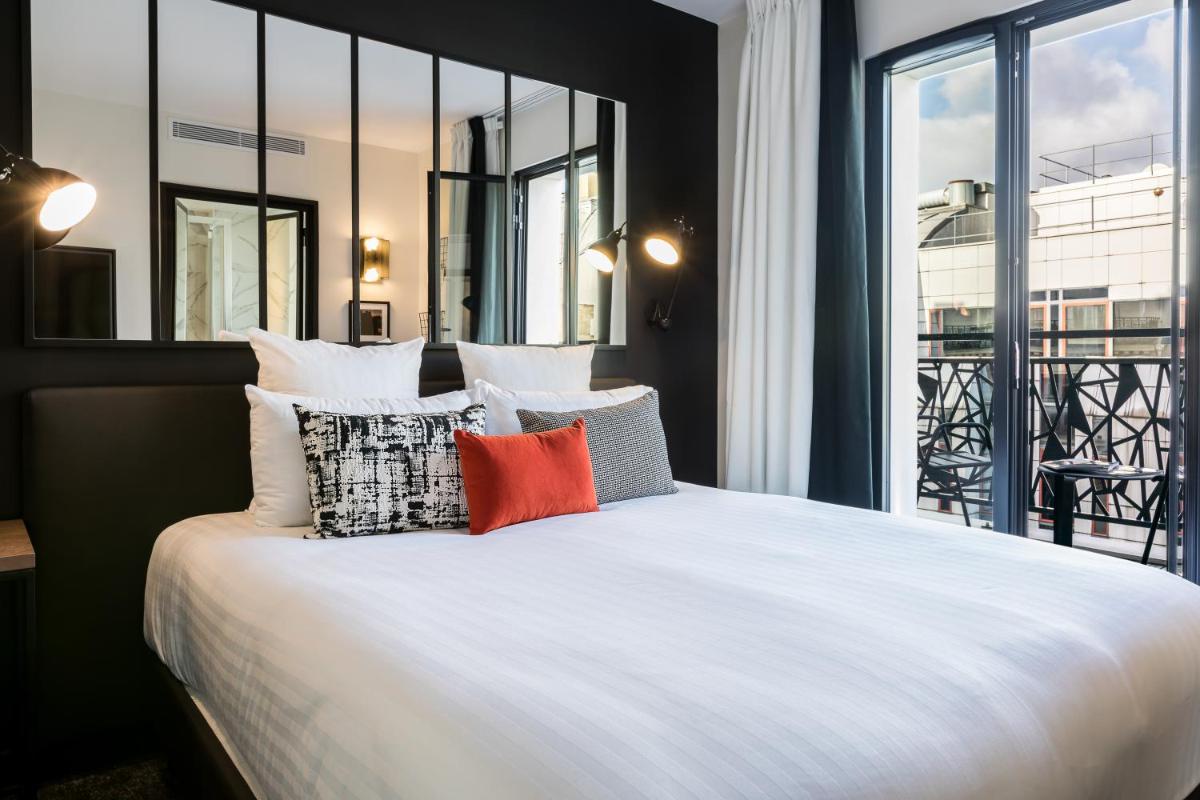 une chambre avec un grand lit blanc avec des oreillers dans l'établissement Laz' Hotel Spa Urbain Paris, à Paris 32 autres photos