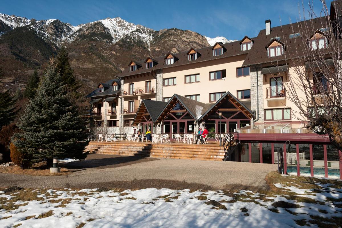 un gran edificio frente a una montaña en SOMMOS Hotel Benasque Spa, en Benasque