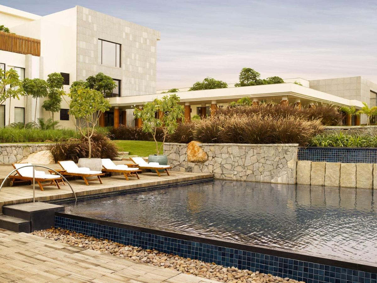 a pool in front of a building at Hyatt Hyderabad Gachibowli in Hyderabad
