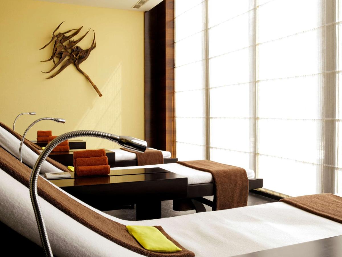 a hospital room with two beds and a crab on the wall at Hyatt Hyderabad Gachibowli in Hyderabad