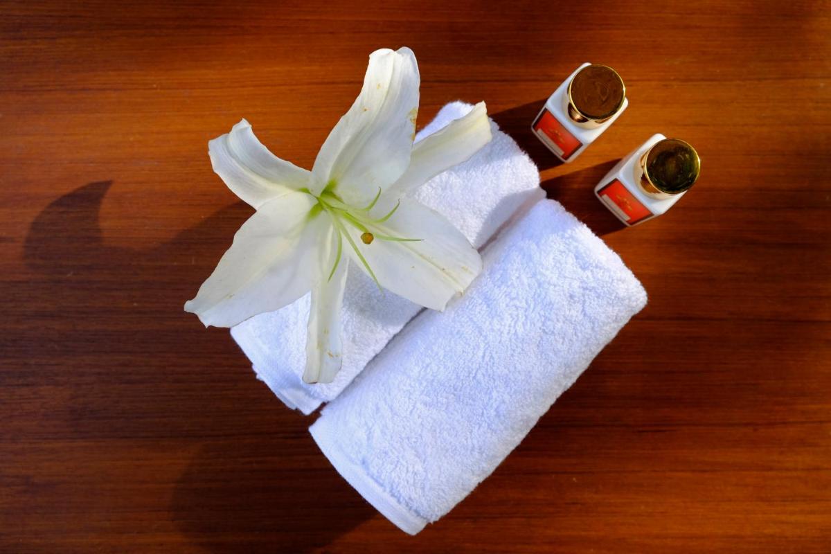 a white flower sitting on top of a towel at Saraca Hotel Lucknow in Lucknow