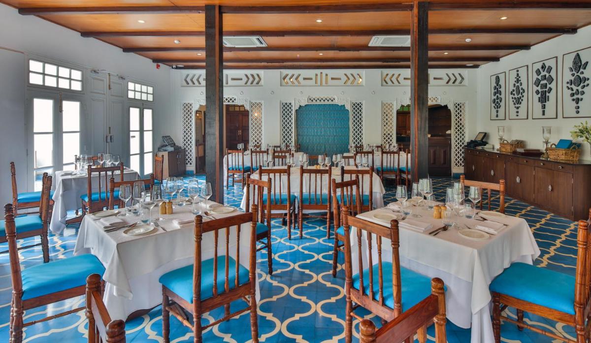 a dining room with tables and chairs in it at Saraca Hotel Lucknow in Lucknow