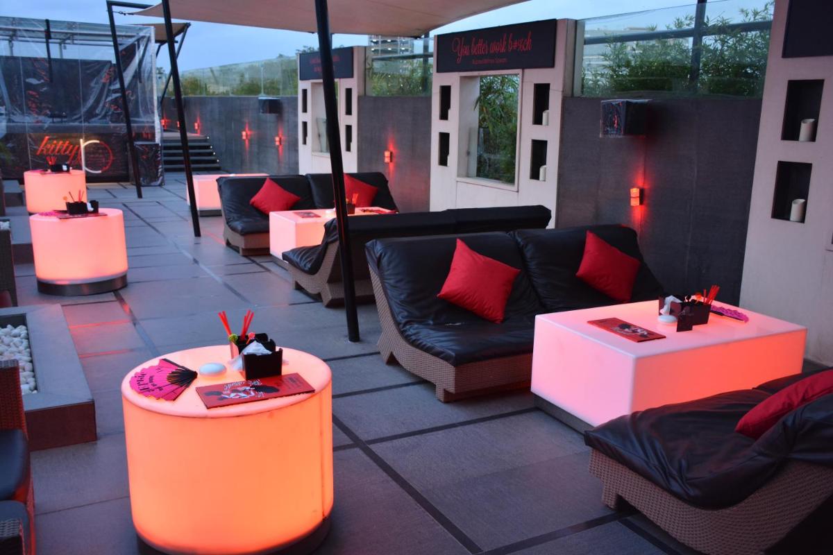 an outdoor patio with couches and tables and lights at The Lalit Ashok in Bengaluru an outdoor patio with couches and tables and lights at The Lalit Ashok in Bengaluru