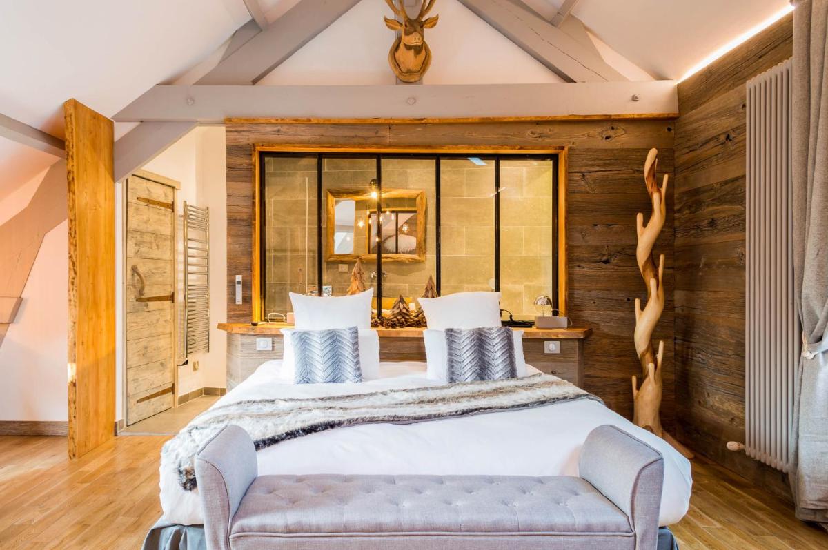 une chambre avec un grand lit et un canapé dans l'établissement Les Jardins d'Epicure, à Bray-et-Lû