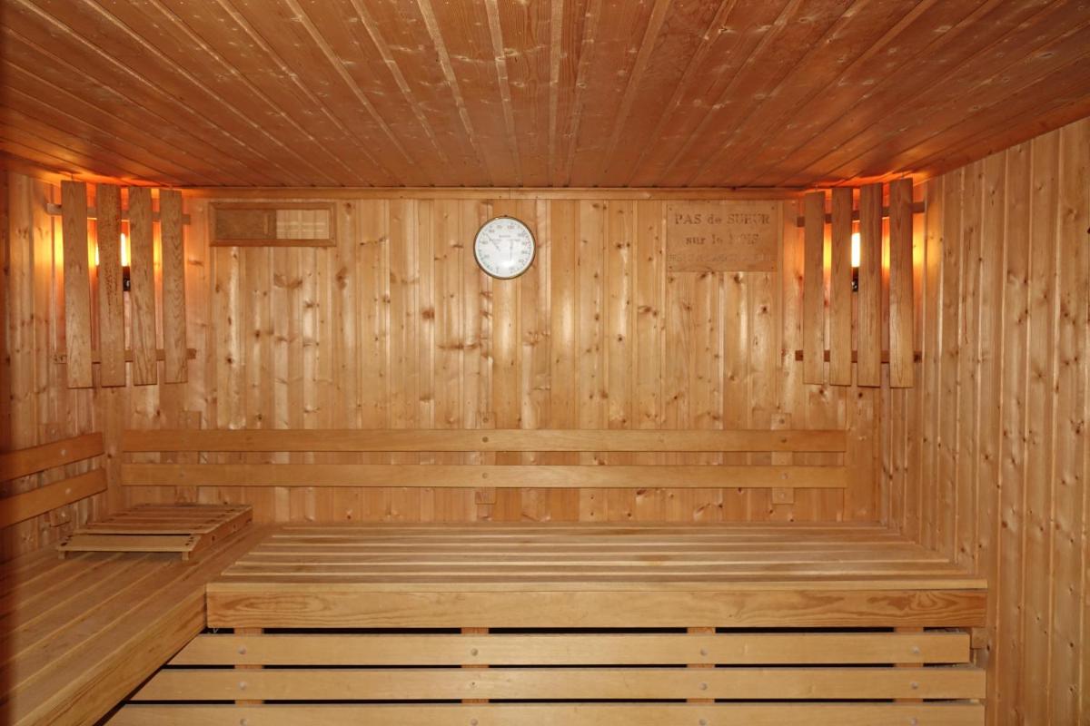 un sauna en bois avec une horloge sur le mur dans l'établissement Hotel-Spa & Restaurant Logis Domaine Langmatt, à Murbach