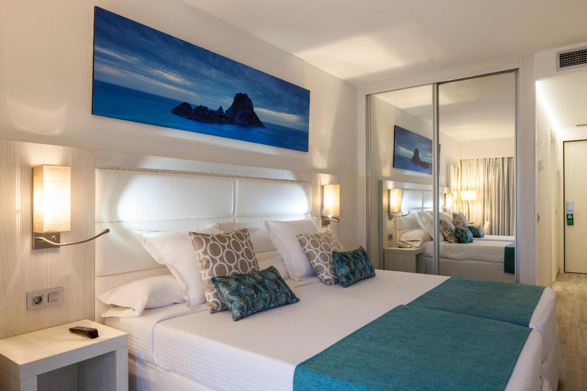 Un dormitorio con una gran cama blanca con dos almohadas. en Ibiza Corso Hotel & Spa, en Ibiza