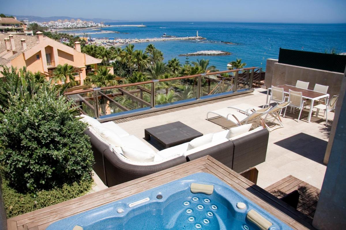 Un jacuzzi en un patio con vista al mar. en Gran Hotel Guadalpín Banus, en Marbella