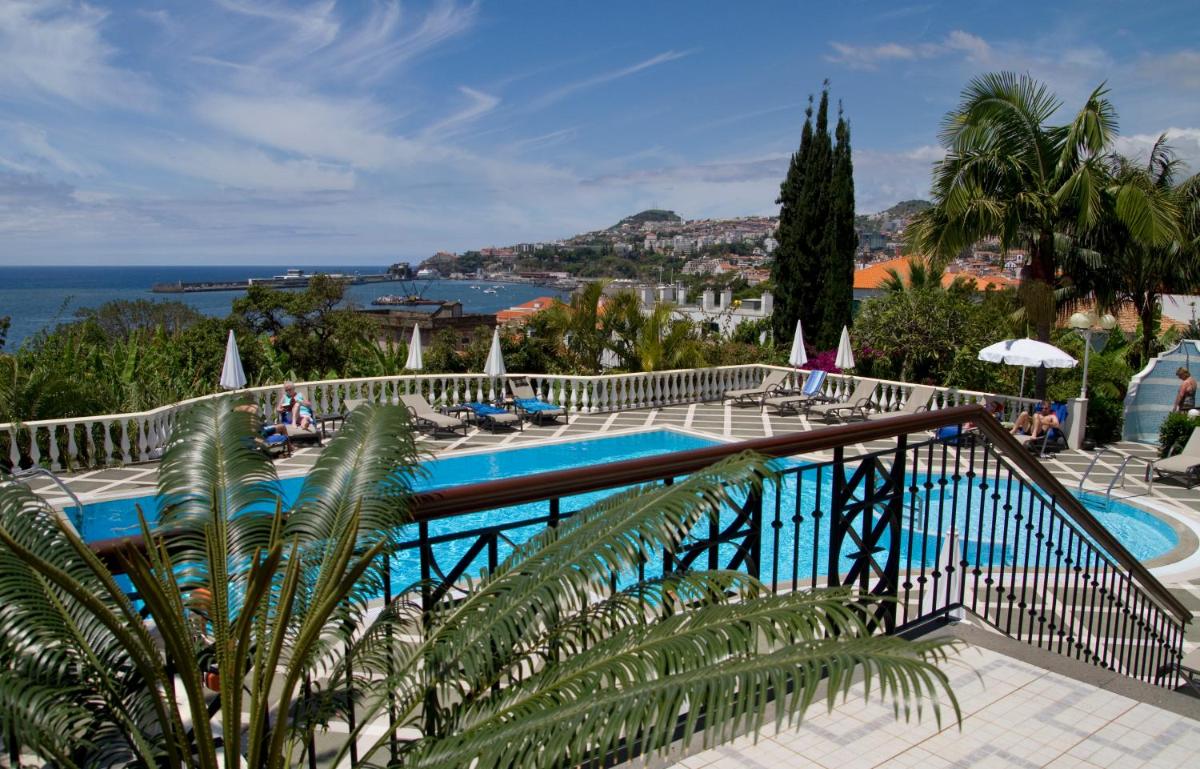 uma vista para uma piscina e para o oceano em Hotel Quinta Bela S Tiago no Funchal