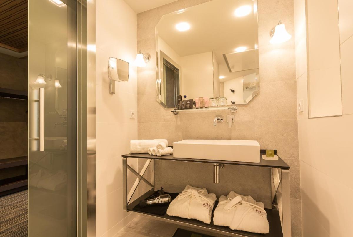 une salle de bain avec un lavabo et un miroir dans l'établissement Plaza Madeleine & Spa, à Sarlat-la-Canéda