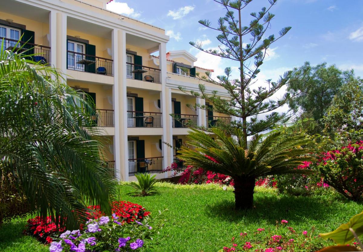um hotel com flores em frente a um edifício em Hotel Quinta Bela S Tiago no Funchal