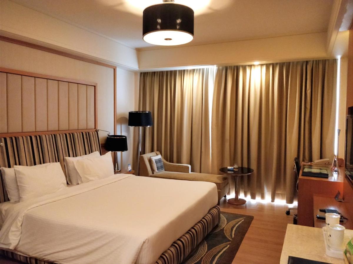 a hotel room with a bed and a chair at Radisson Blu Hotel, Nagpur in Nagpur
