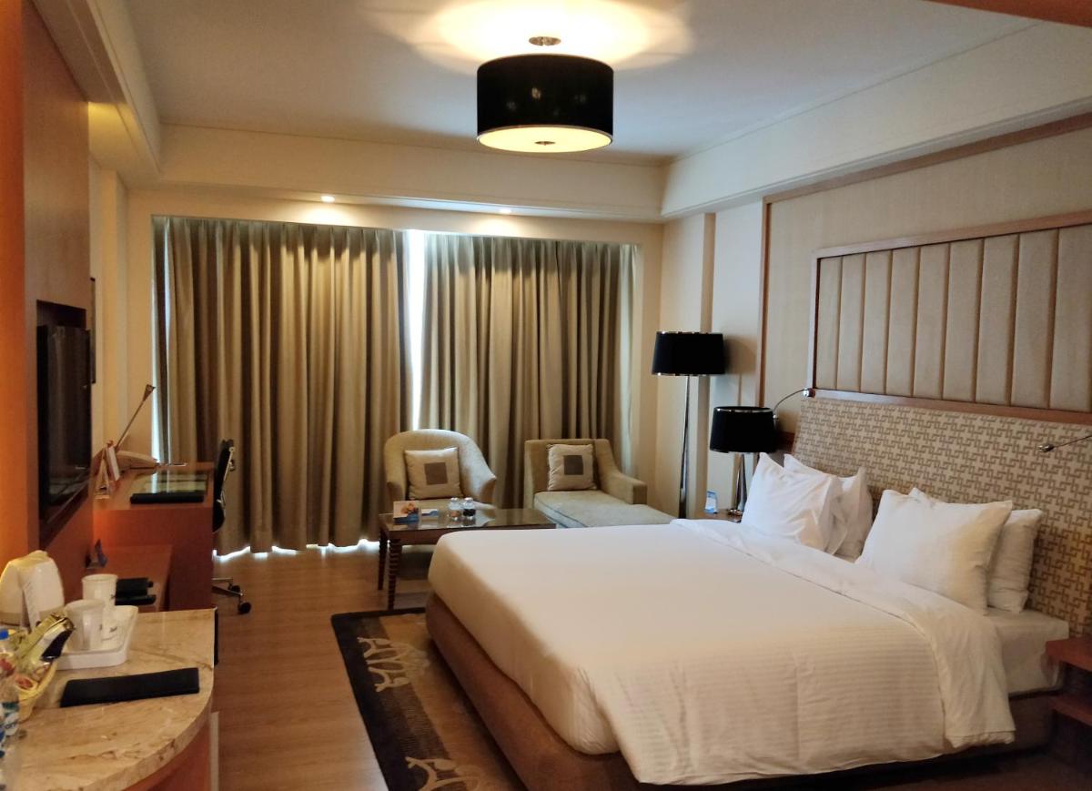 a hotel room with a large bed and a chair at Radisson Blu Hotel, Nagpur in Nagpur