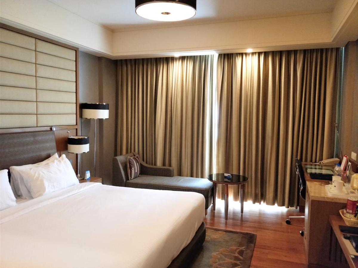 a hotel room with a large bed and a chair at Radisson Blu Hotel, Nagpur in Nagpur