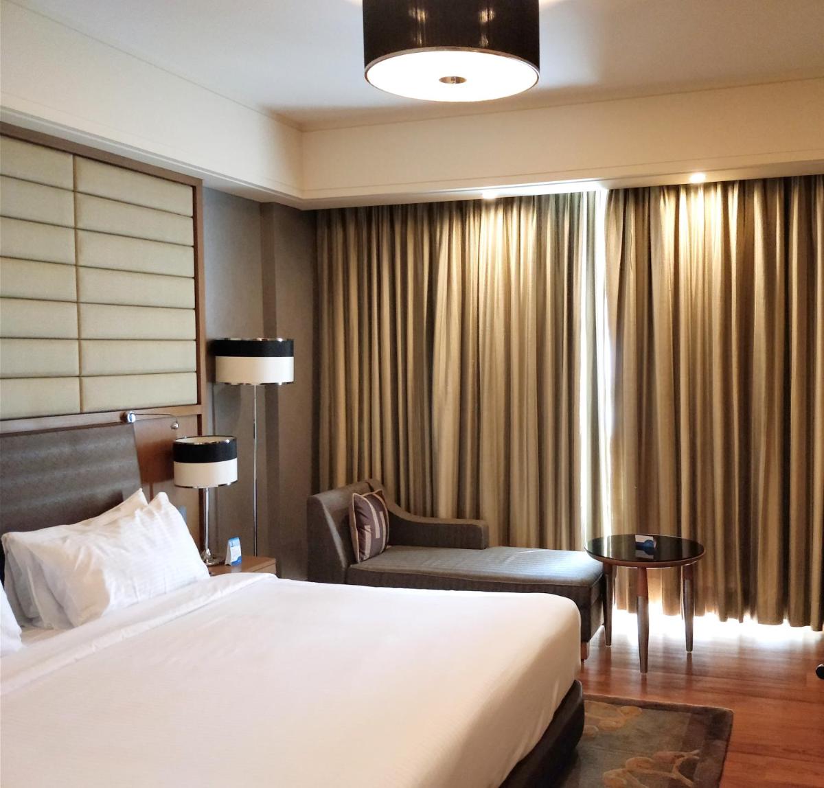 a hotel room with a bed and a chair at Radisson Blu Hotel, Nagpur in Nagpur