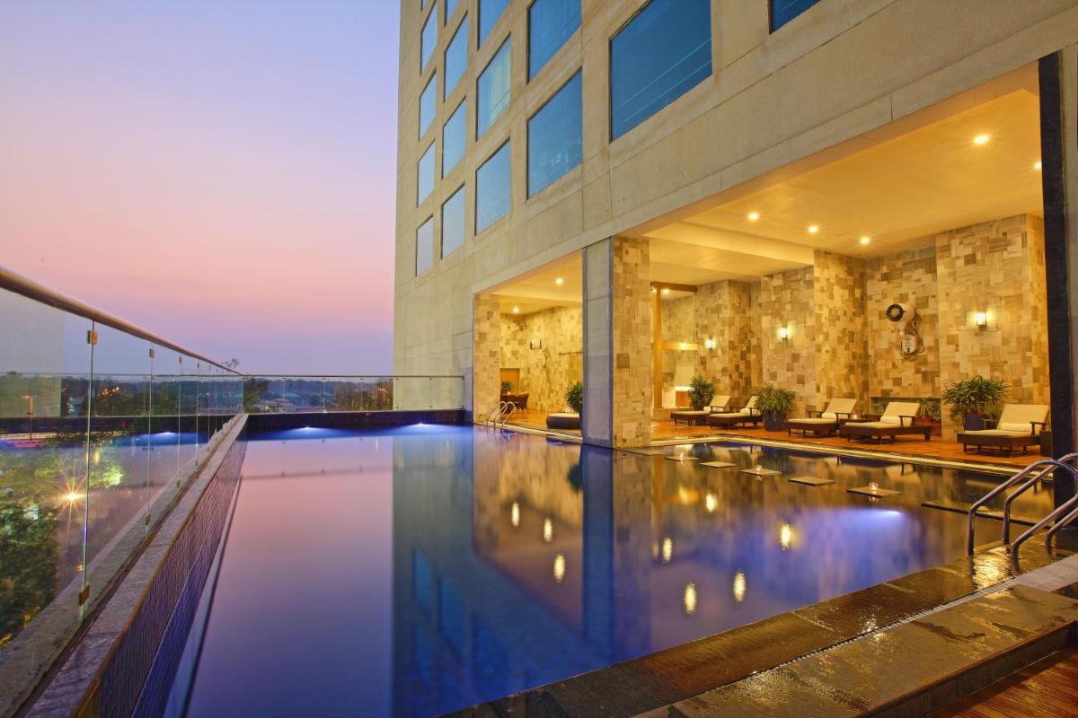 a large building with a pool in front of a building at Novotel Ahmedabad in Ahmedabad